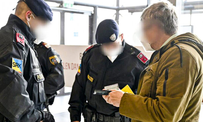 Austrian police officers check a man's identity and vaccination certificate during a control in Voesendorf, Moedling district, Austria, on Nov. 16, 2021. (Hans Punz/APA/AFP via Getty Images)
