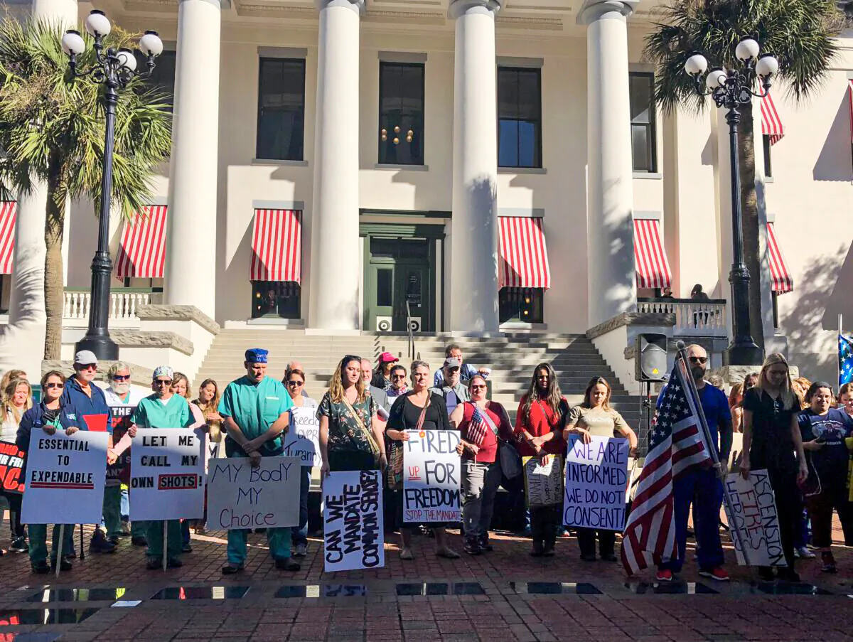 People stand in a courtyard outside the Florida Capitol on Nov. 16 to urge lawmakers to pass bills against mask and vaccine mandates. (Nanette Holt for The Epoch Times)
