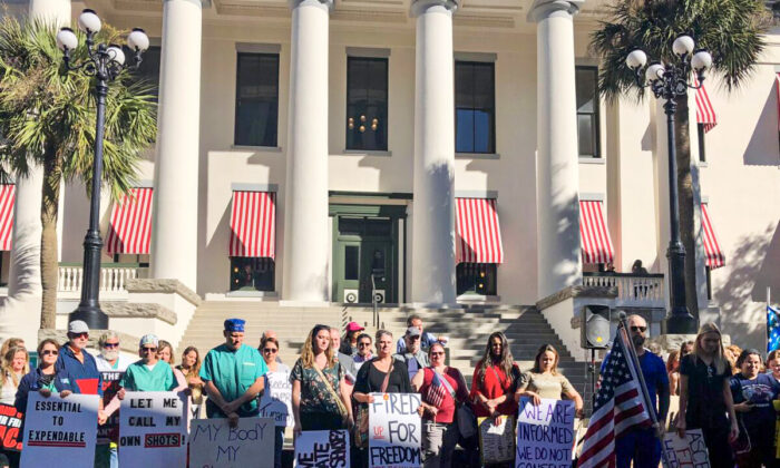 People stand in a courtyard outside the Florida Capitol on Nov. 16 to urge lawmakers to pass bills against mask and vaccine mandates. (Nanette Holt for The Epoch Times)