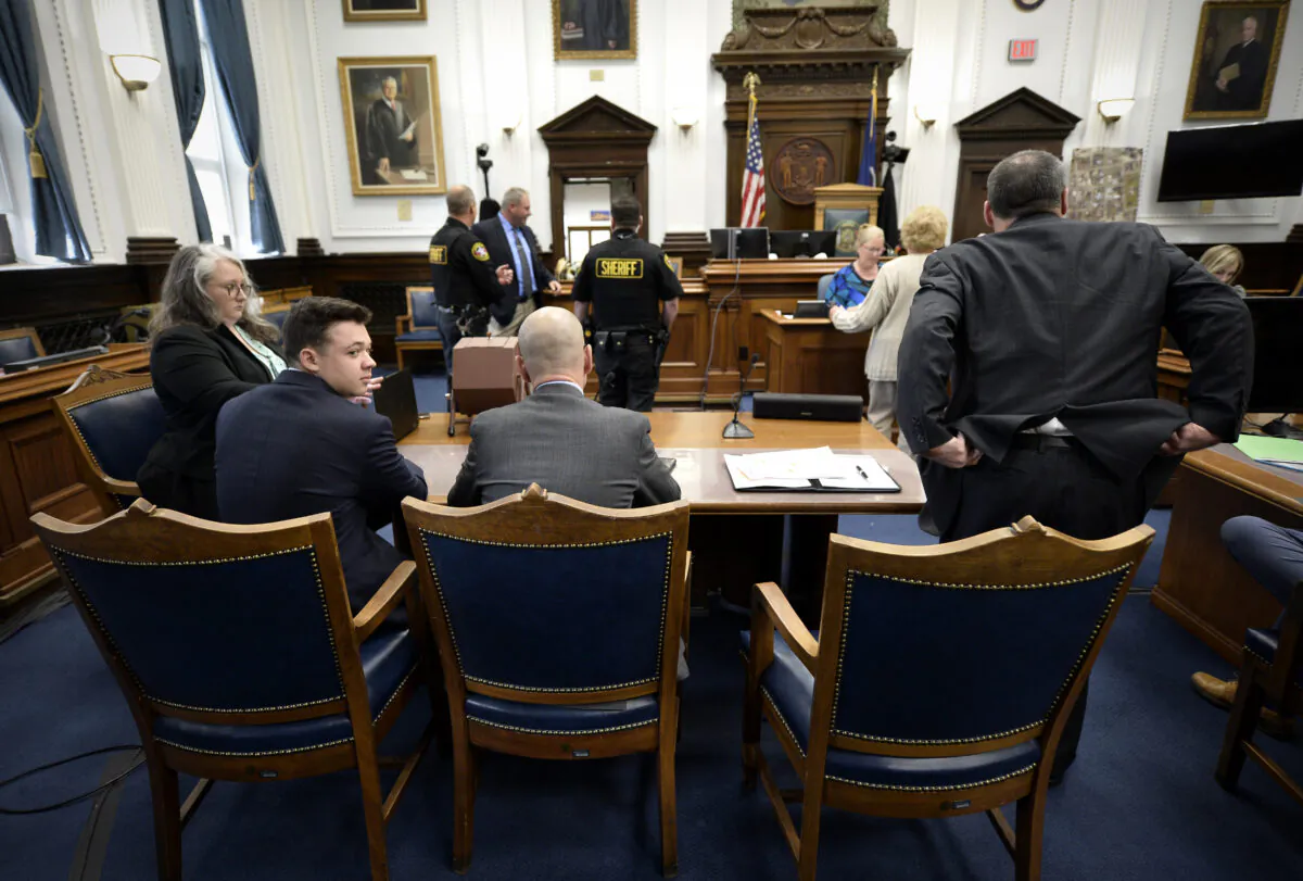 Kyle Rittenhouse, second from left, waits with his legal team for the day to start at his trial at the Kenosha County Courthouse in Kenosha, Wis., on Nov. 16, 2021. (Sean Krajacic/The Kenosha News via AP, Pool)