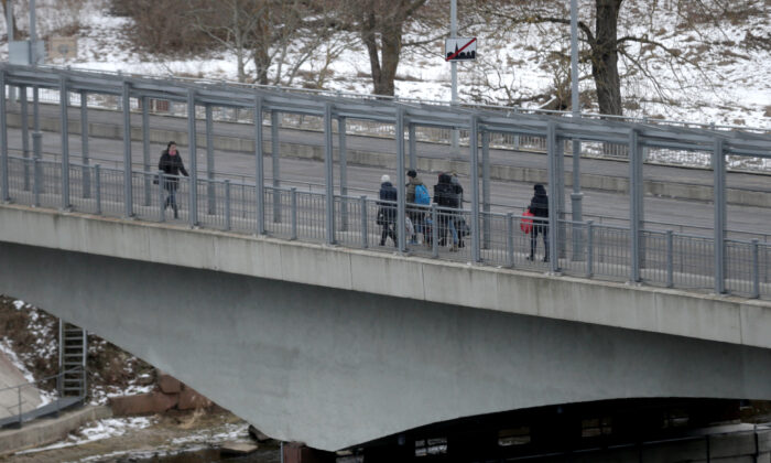 People walk on the bridge over the river Narva at the border crossing point with Russia in Narva, Estonia, on Feb. 16, 2017. (Ints Kalnins/Reuters)