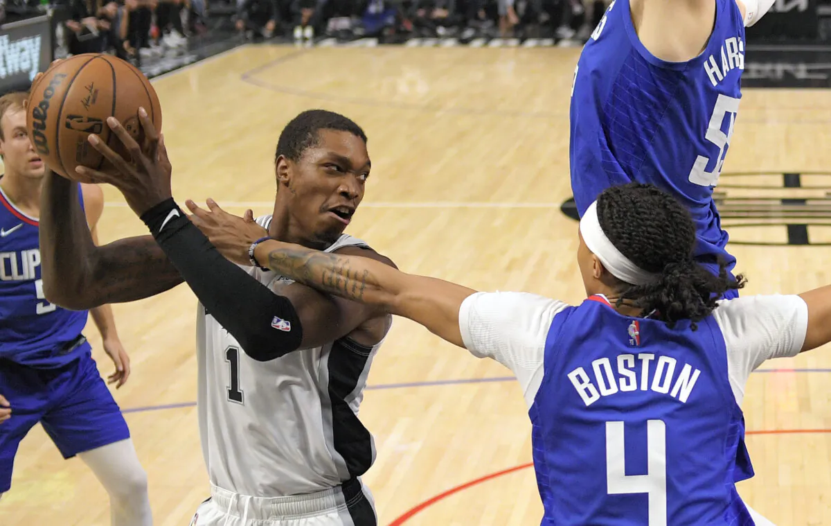 San Antonio Spurs guard Lonnie Walker IV, left, tries to pass as Los Angeles Clippers guard Brandon Boston Jr. defends during the second half of an NBA basketball game in Los Angeles on Nov. 16, 2021. (AP Photo/Mark J. Terrill)