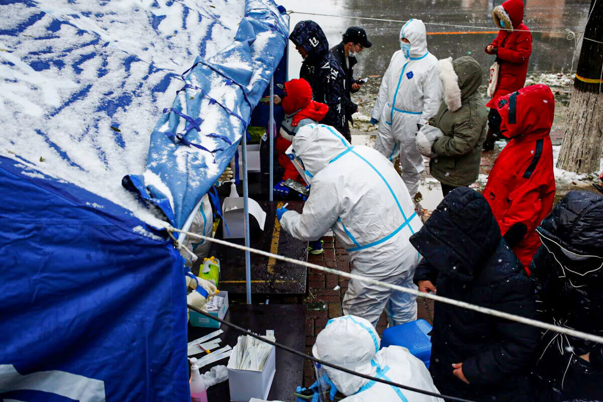 People line up for nucleic acid testing in the snow at a testing site in Dalian, Liaoning province, China, on Nov. 8, 2021. (cnsphoto via Reuters)