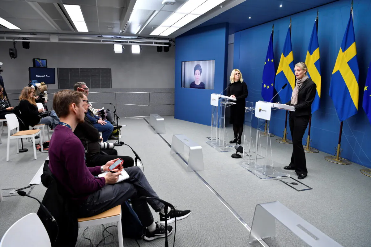Minister for Culture and Democracy Amanda Lind (on screen), Minister for Health and Social Affairs Lena Hallengren, and Head of Sweden's Public Health Agency Karin Tegmark Wisell attend a press conference on new restrictions to curb the spread of the coronavirus disease, in Stockholm, on Nov. 17, 2021. (Jessica Gow/TT News Agency/via Reuters)