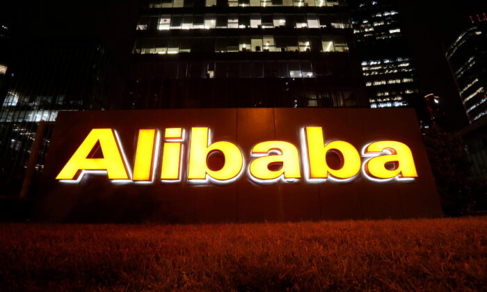  logo of Alibaba Group is lit up at its office building in Beijing, on Aug. 9, 2021. (Tingshu Wang/Reuters)