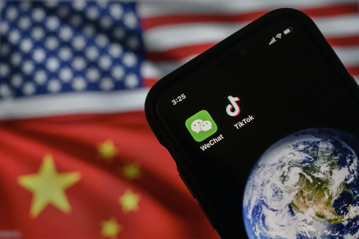 A mobile phone can be seen displaying the logos for Chinese apps WeChat and TikTok in front of a monitor showing the flags of the United States and China on an internet page, in Beijing, on Sept. 22, 2020. (Kevin Frayer/Getty Images)