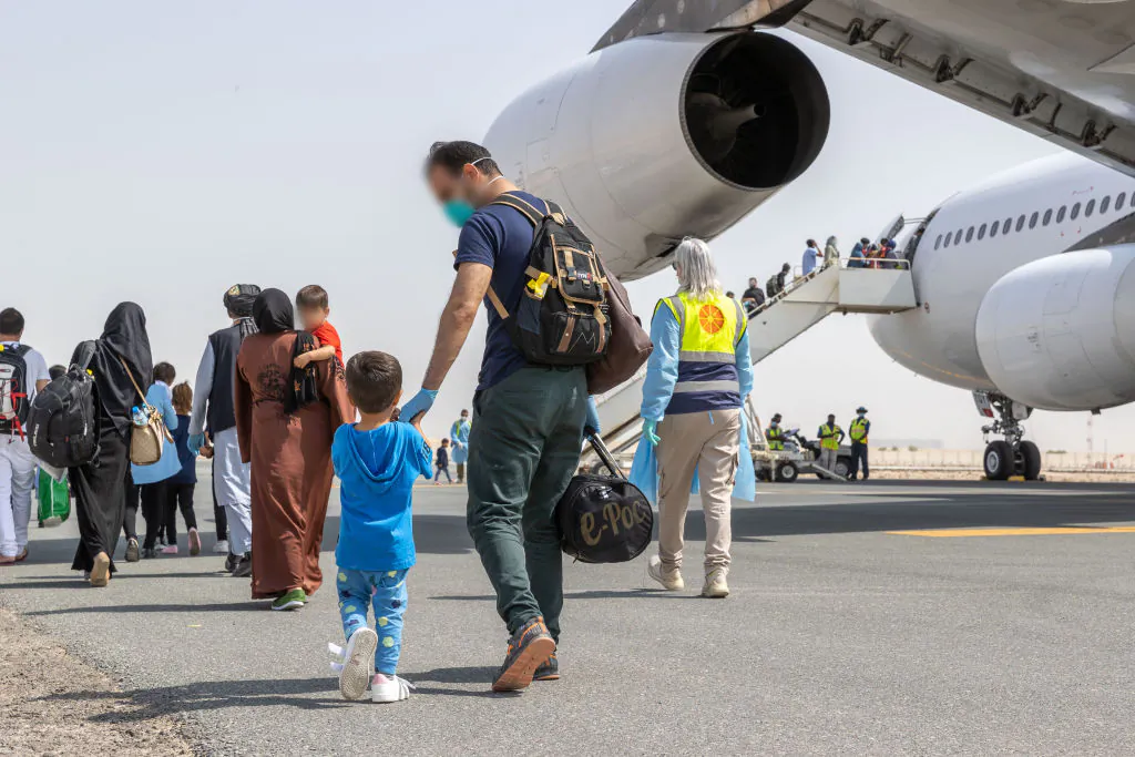 In this handout provided by the Australian Department of Defence, Afghanistan evacuees board a flight to Australia from the Australian Defence Force's main operating base in the Middle East region. (LACW Jacqueline Forrester/Australian Department of Defence via Getty Images)