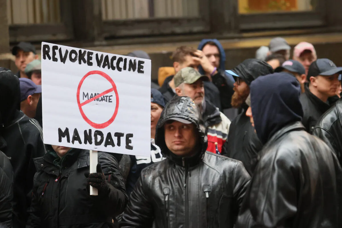 Chicago police officers along with other city workers and their supporters protest against the mayor's COVID-19 vaccination policy for city employees, at city hall in Chicago on Oct. 25, 2021. (Scott Olson/Getty Images)