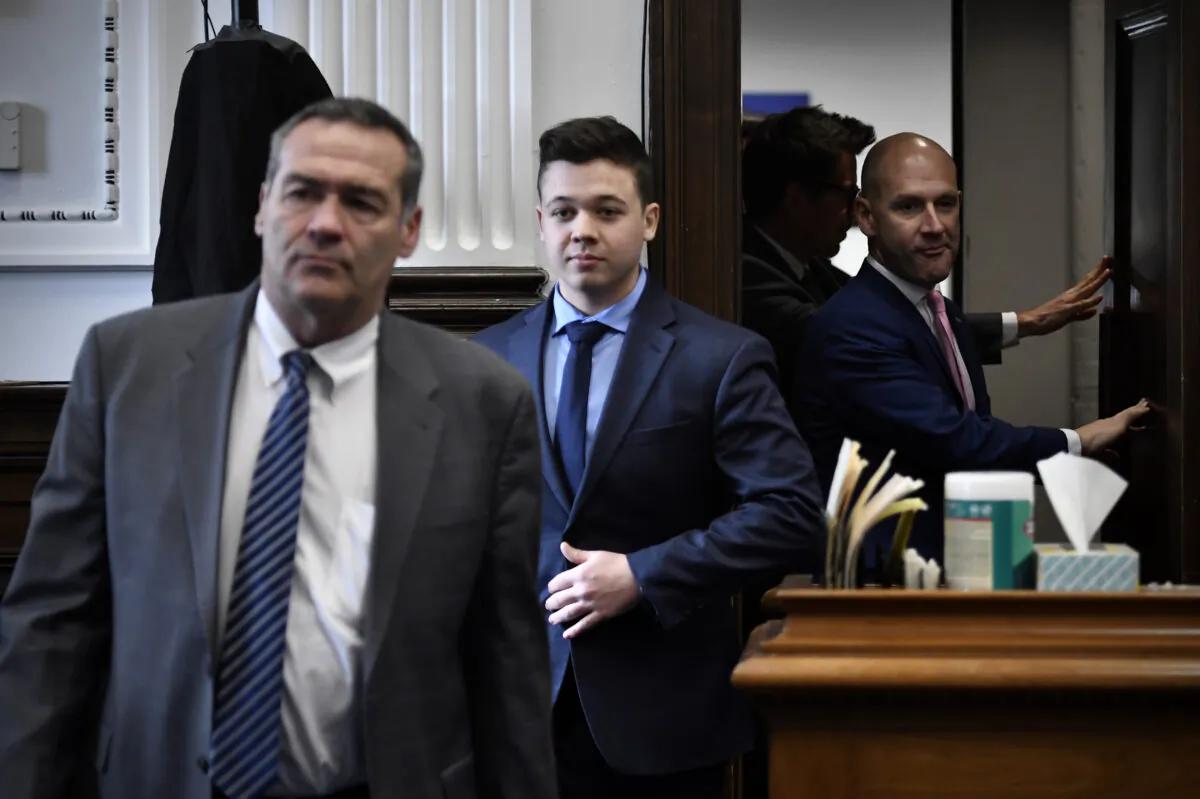 Kyle Rittenhouse, center, enters the courtroom with his attorneys Mark Richards, left, and Corey Chirafisi for a meeting called by Judge Bruce Schroeder at the Kenosha County Courthouse in Kenosha, Wis., on Nov. 18, 2021. (Sean Krajacic/The Kenosha News via AP/pool)