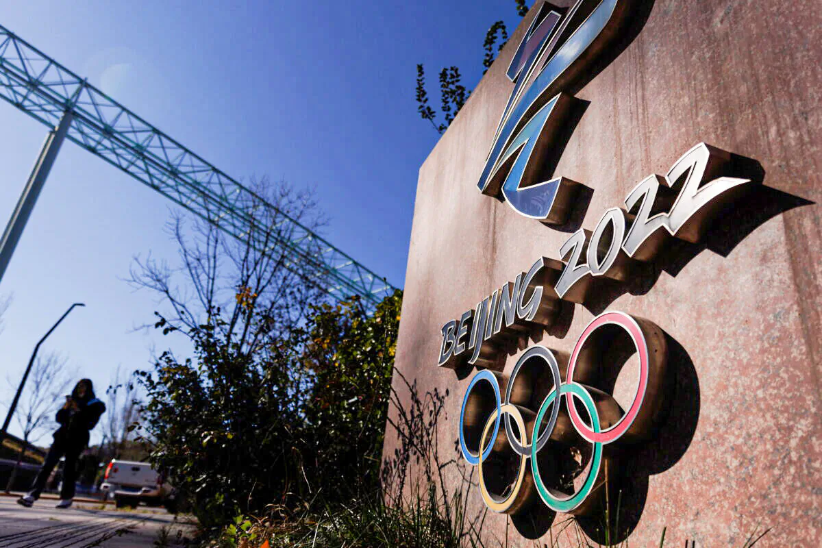 A woman walks past the Beijing 2022 logo that is seen outside the headquarters of the Beijing Organizing Committee for the 2022 Olympic and Paralympic Winter Games in Shougang Park, the site of a former steel mill, in Beijing, China, Nov. 10, 2021. (Thomas Peter/Reuters)