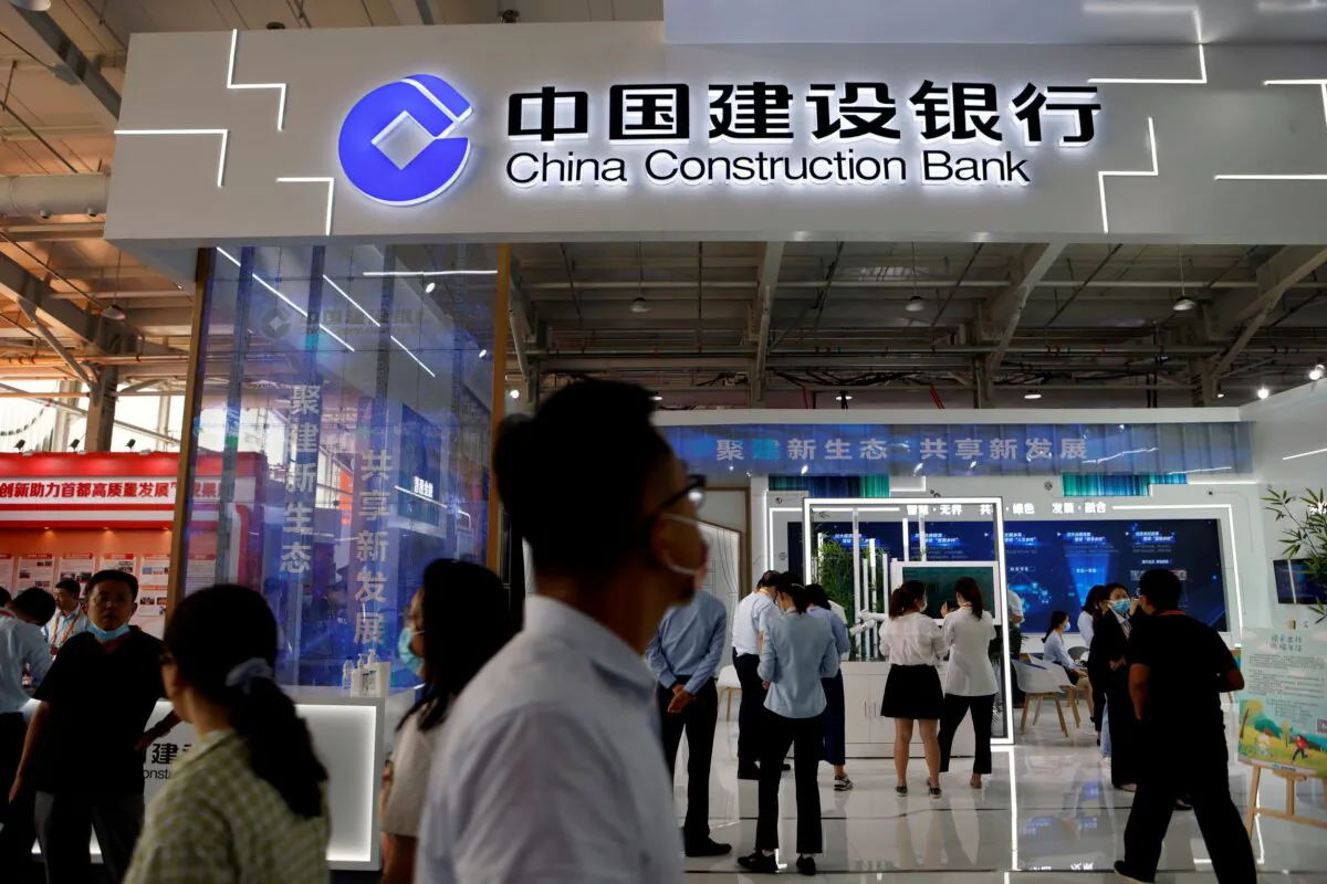 People walk past the China Construction Bank booth at the 2021 China International Fair for Trade in Services in Beijing on Sept. 3, 2021. (Florence Lo/Reuters)