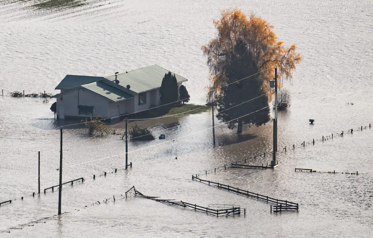 A house on a farm is surrounded by floodwaters in Abbotsford, B.C., on Nov. 17, 2021. (The Canadian Press/Darryl Dyck)