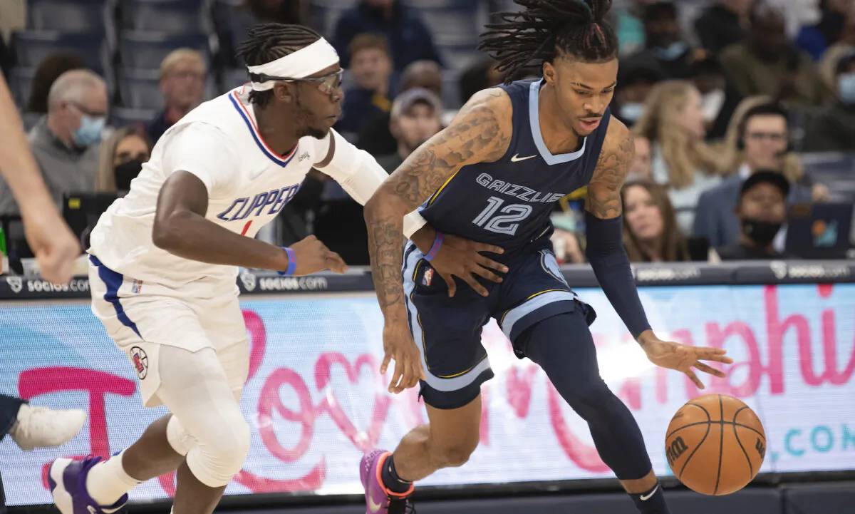 Los Angeles Clippers guard Reggie Jackson (1) defends against Memphis Grizzlies guard Ja Morant (12) in the first half of an NBA basketball game in Memphis, Tenn., on Nov. 18, 2021. (AP Photo/Nikki Boertman)
