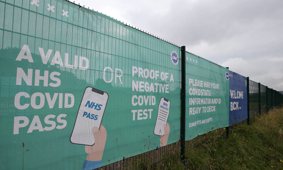 NHS COVID Pass and Negative COVID test advice is seen on a banner outside the stadium prior to the Premier League match between Brighton & Hove Albion and Watford at American Express Community Stadium in Brighton, England, on Aug. 21, 2021. (Steve Bardens/Getty Images)