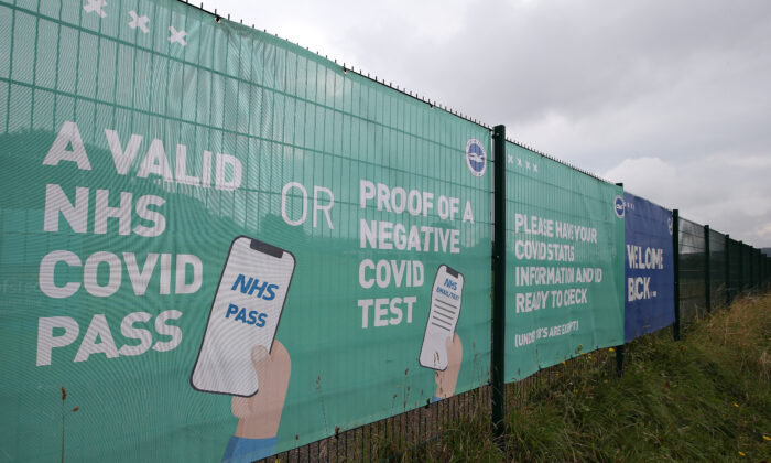 NHS COVID Pass and Negative COVID test advice is seen on a banner outside the stadium prior to the Premier League match between Brighton & Hove Albion and  Watford at American Express Community Stadium in Brighton, England, on Aug. 21, 2021. (Steve Bardens/Getty Images)
