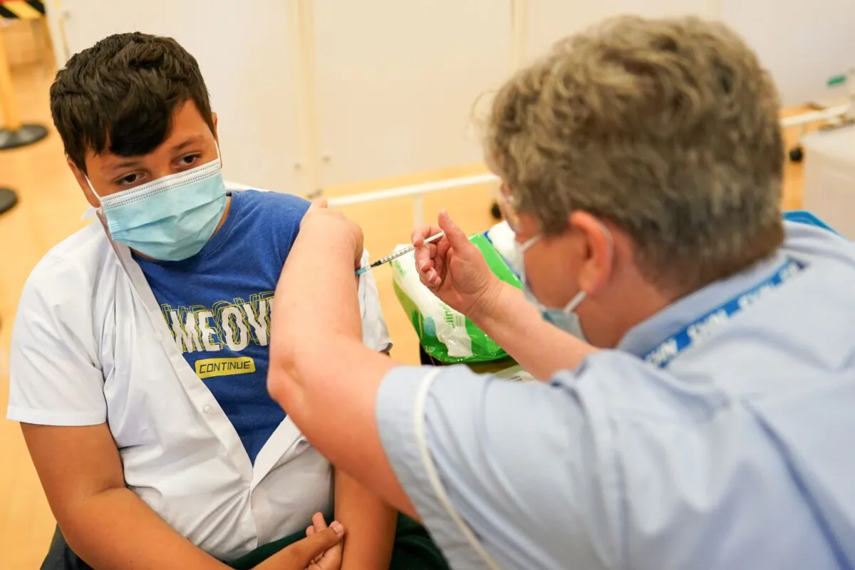 Felix Dima, 13, from Newcastle receives the Pfizer-BioNTech COVID-19 vaccine at the Excelsior Academy in Newcastle upon Tyne, England, on Sept. 22, 2021. (Ian Forsyth/Getty Images)
