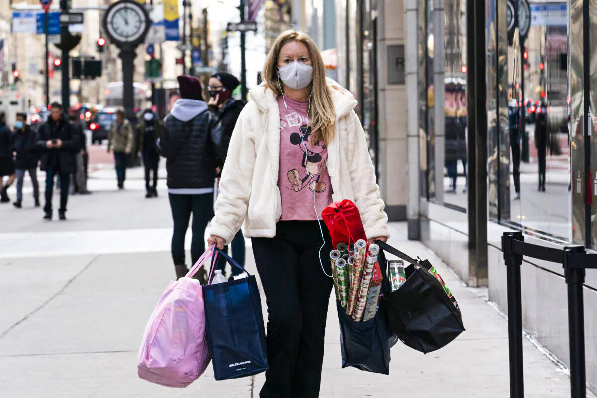 A woman carries shopping bags in New York on Dec. 10, 2020. (Mark Lennihan/AP Photo)