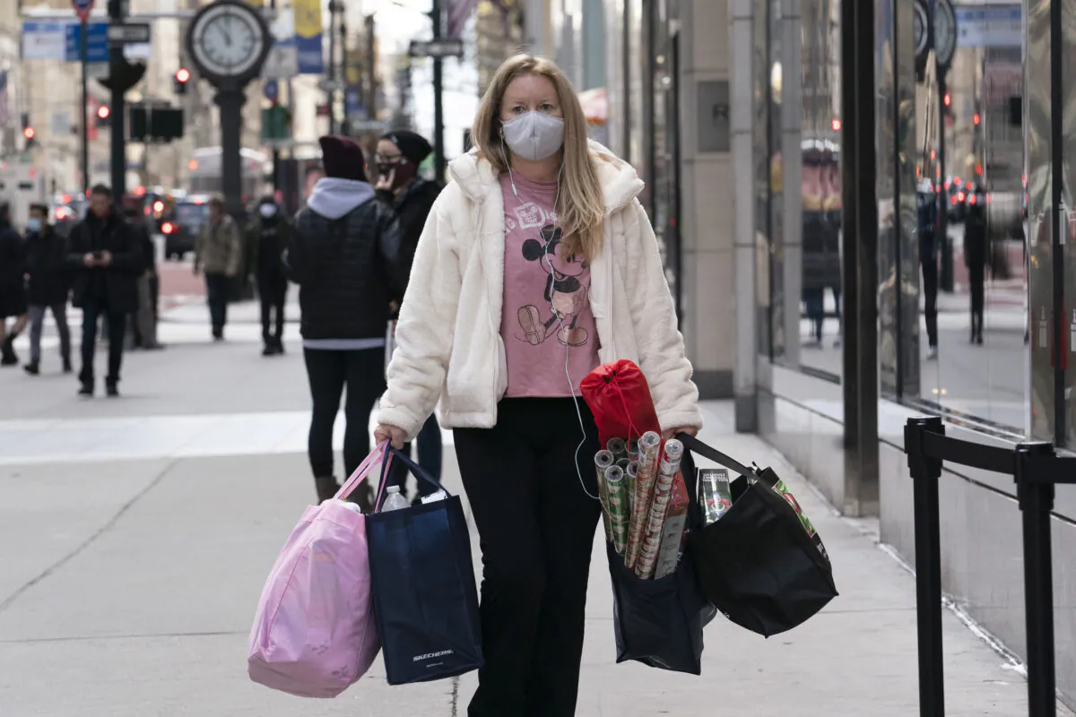 A woman carries shopping bags in New York on Dec. 10, 2020. (Mark Lennihan/AP Photo)