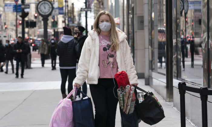 A woman carries shopping bags in New York on Dec. 10, 2020. (Mark Lennihan/AP Photo)