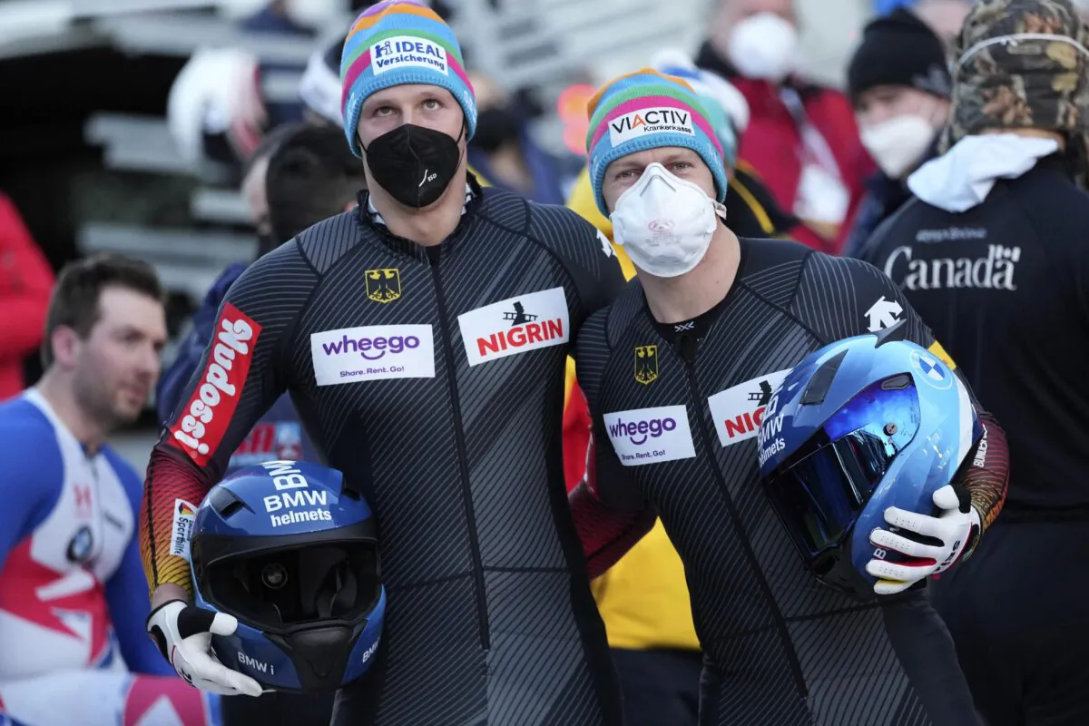 Francesco Friedrich (R) and Alexander Schueller of Germany pose after winning the men's two-man bobsleigh World Cup race in Igls, near Innsbruck, Austria, on Nov. 20, 2021. (Matthias Schrader/AP Photo)