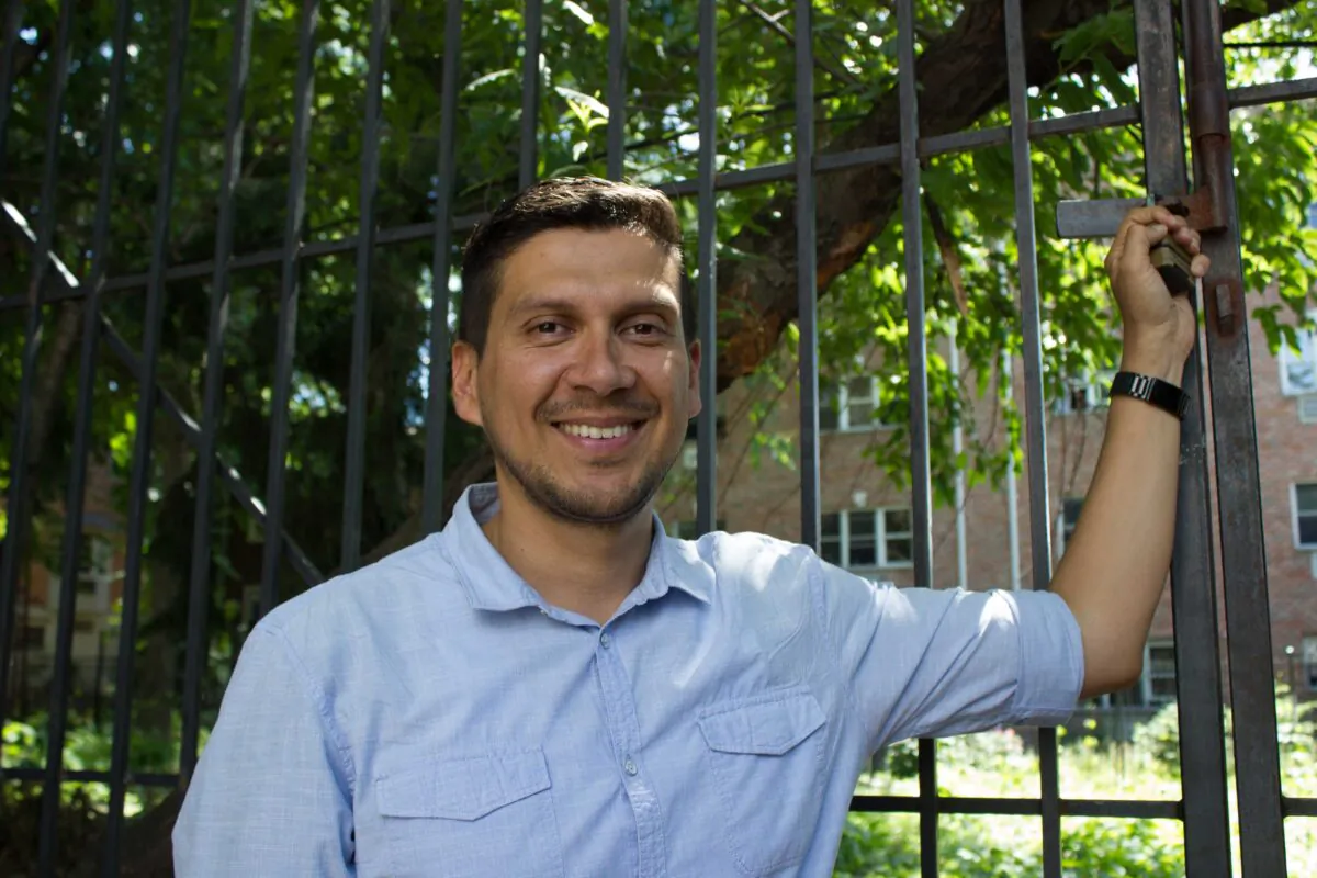 Carlos Martinez in front of the gates of the Leverich Burial Ground in Jackson Heights. (Beatriz Gil/Hibridos Collective)