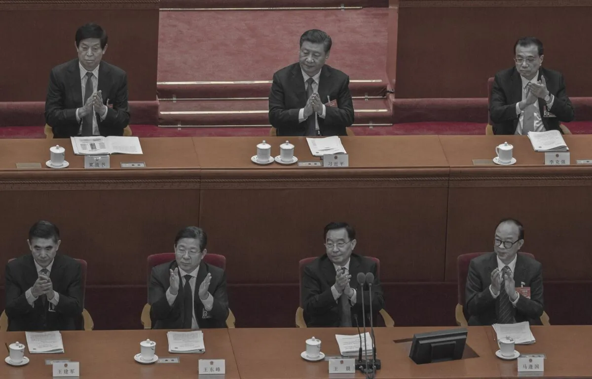 Chinese leader Xi Jinping, top center, Premier Li Keqiang, right, and NPC Chairman Li Zhanshu applaud during a speech at the second plenary session at the Great Hall of the People in Beijing on March 8, 2021. (Kevin Frayer/Getty Images)