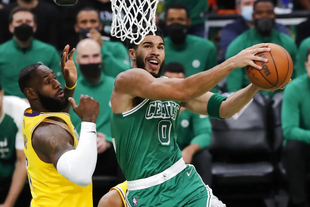 Boston Celtics' Jayson Tatum (0) goes up to shoot against Los Angeles Lakers' LeBron James, left, during the first half of an NBA basketball game, in Boston, on Nov. 19, 2021. (Michael Dwyer/AP Photo)