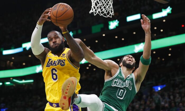Los Angeles Lakers' LeBron James (6) and Boston Celtics' Jayson Tatum (0) battle for a rebound during the first half of an NBA basketball game, in Boston, on Nov. 19, 2021. (Michael Dwyer/AP Photo)