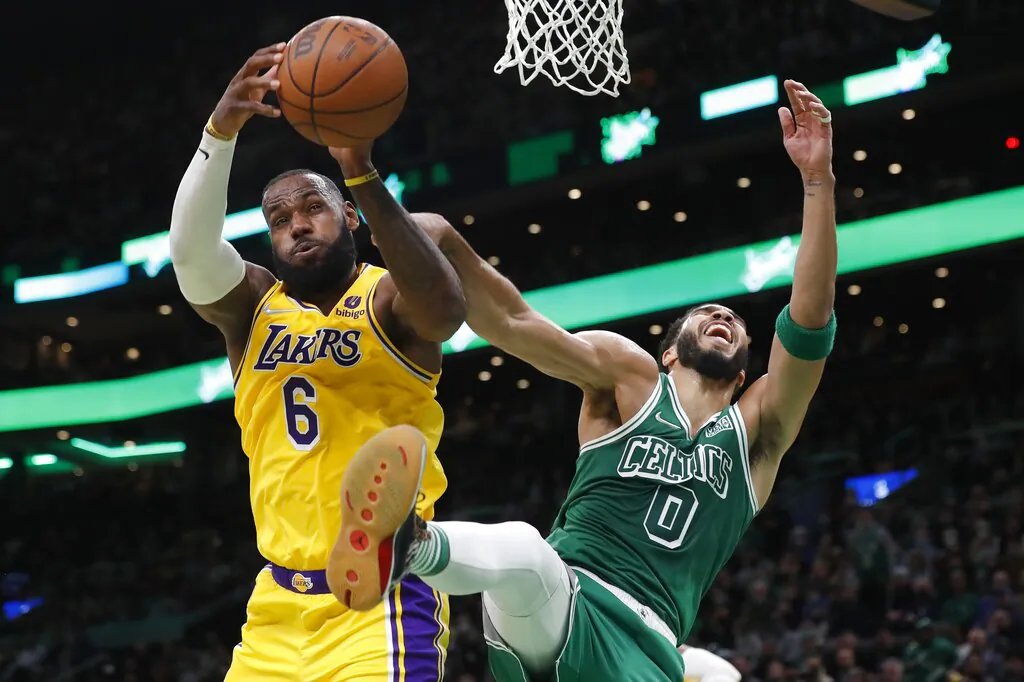 Los Angeles Lakers' LeBron James (6) and Boston Celtics' Jayson Tatum (0) battle for a rebound during the first half of an NBA basketball game, in Boston, on Nov. 19, 2021. (Michael Dwyer/AP Photo)