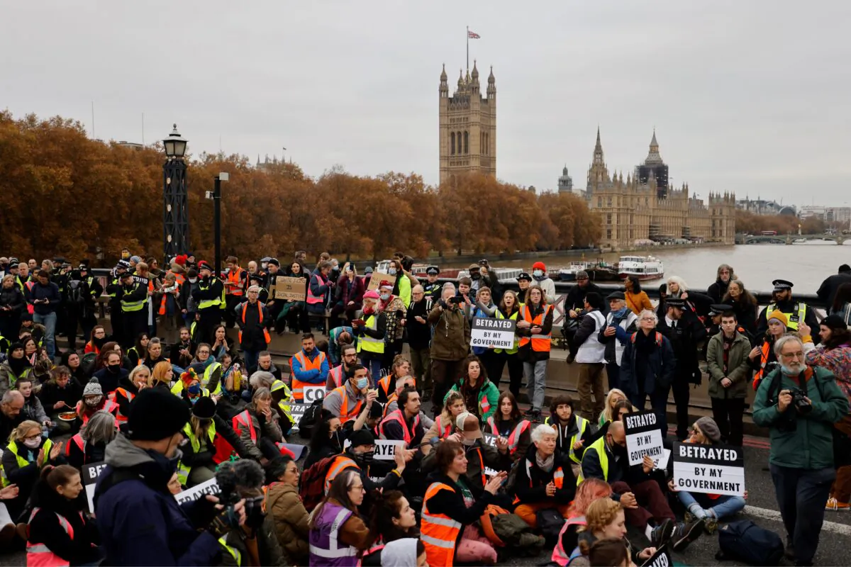 Climate change activists block traffic during a protest action in solidarity with activists from the Insulate Britain group who received prison terms for blocking roads, on Lambeth Bridge in central London, on Nov. 20, 2021. (Tolga Akmen/AFP via Getty Images)