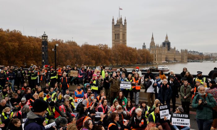 Climate change activists block traffic during a protest action in solidarity with activists from the Insulate Britain group who received prison terms for blocking roads, on Lambeth Bridge in central London, on Nov. 20, 2021. (Tolga Akmen/AFP via Getty Images)