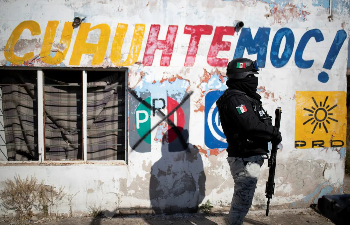 A member of the National Guard keeps watch at a crime scene where assailants left 10 bodies of men hanging from a bridge, in Ciudad Cuauhtemoc, in Zacatecas state, Mexico, on Nov. 18, 2021. (Guillermo Moreno/Reuters)