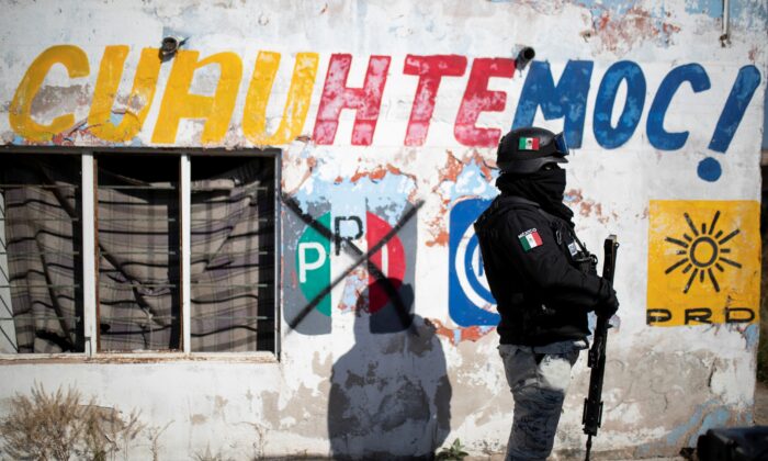 A member of the National Guard keeps watch at a crime scene where assailants left 10 bodies of men hanging from a bridge, in Ciudad Cuauhtemoc, in Zacatecas state, Mexico, on Nov. 18, 2021. (Guillermo Moreno/Reuters)