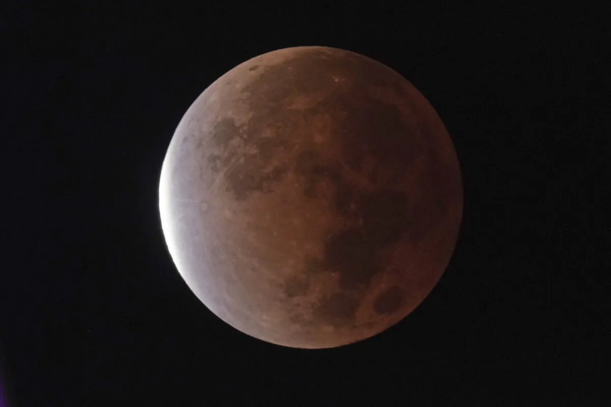 The earth's shadow covers the full moon during a partial lunar eclipse in Kansas City, Mo, Nov. 19, 2021. (Charlie Riedel/AP Photo)