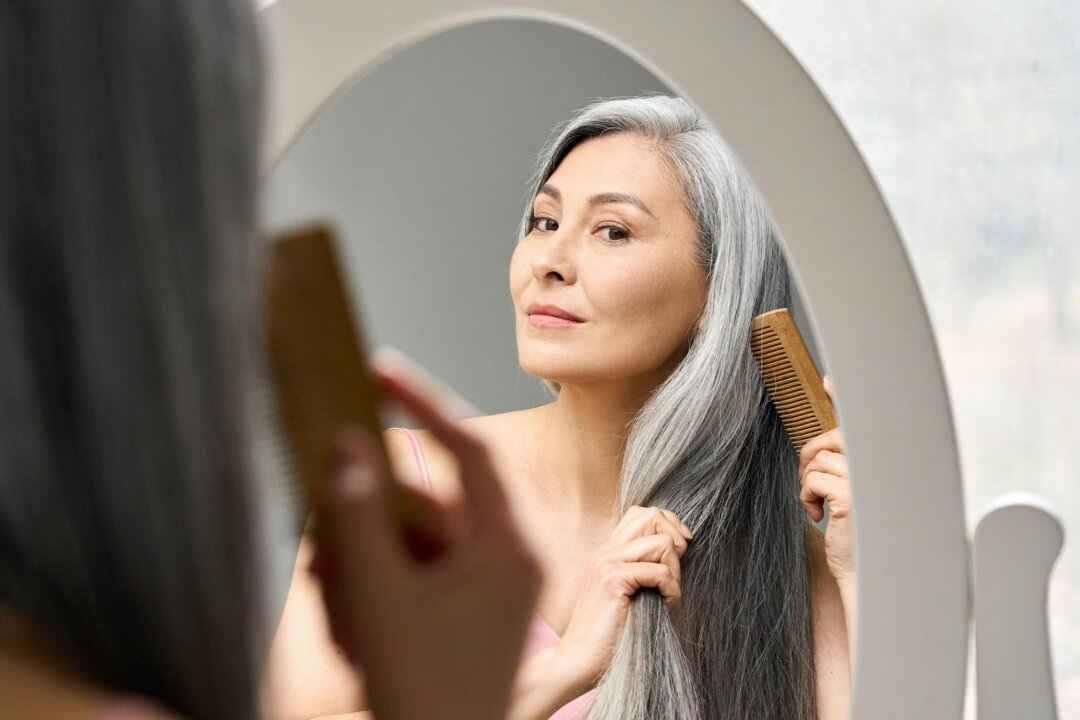 A woman brushing her hair in a stock photo. (insta_photos/Shutterstock)