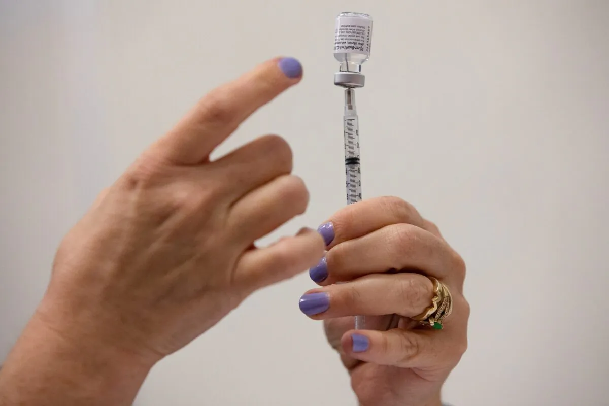 A nurse fills up syringes for patients as they receive their COVID-19 booster vaccination during a Pfizer-BioNTech vaccination clinic in Southfield, Mich., on Sept. 29, 2021. (Emily Elconin/Reuters)