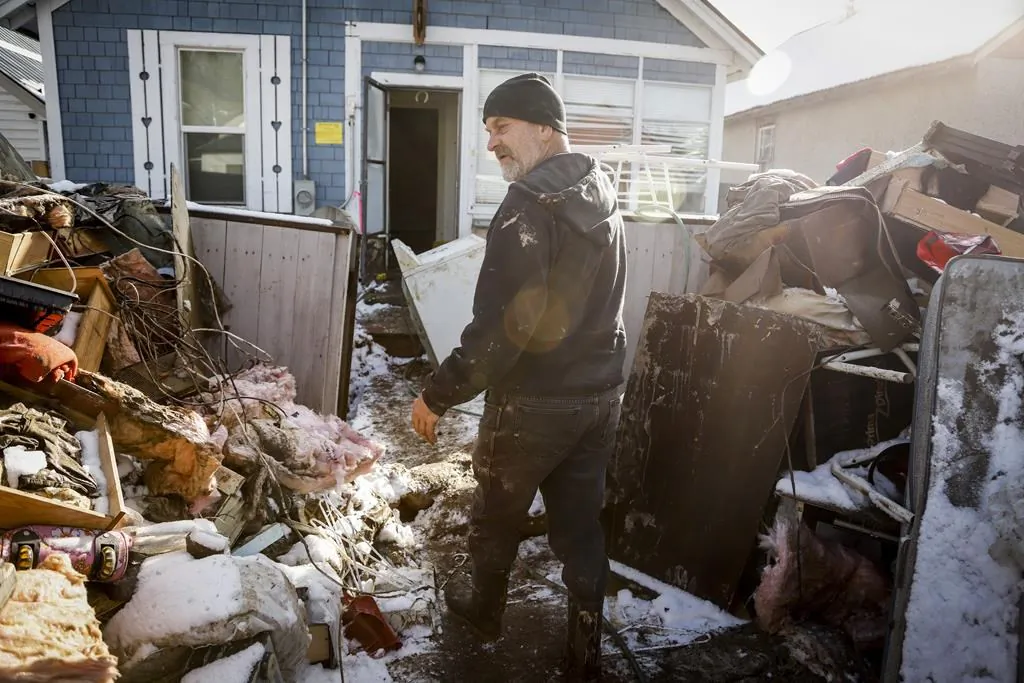 Mario Loutef cleans up after his home was flooded in Princeton, B.C., Nov. 20, 2021. (The Canadian Press/Jeff McIntosh)