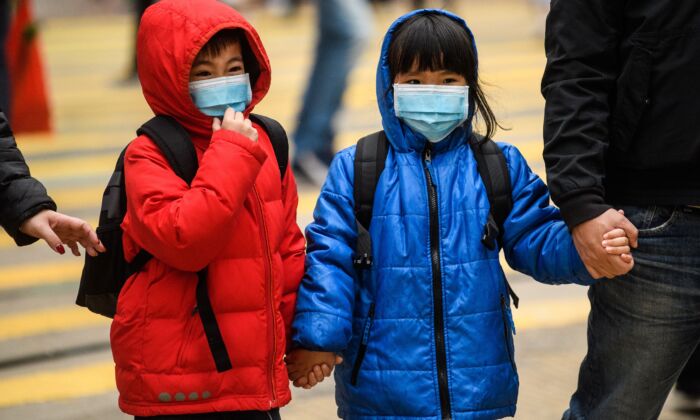 Children wearing masks cross a road during a Lunar New Year of the Rat public holiday in Hong Kong on Jan. 27, 2020. (Anthony Wallace/AFP via Getty Images)