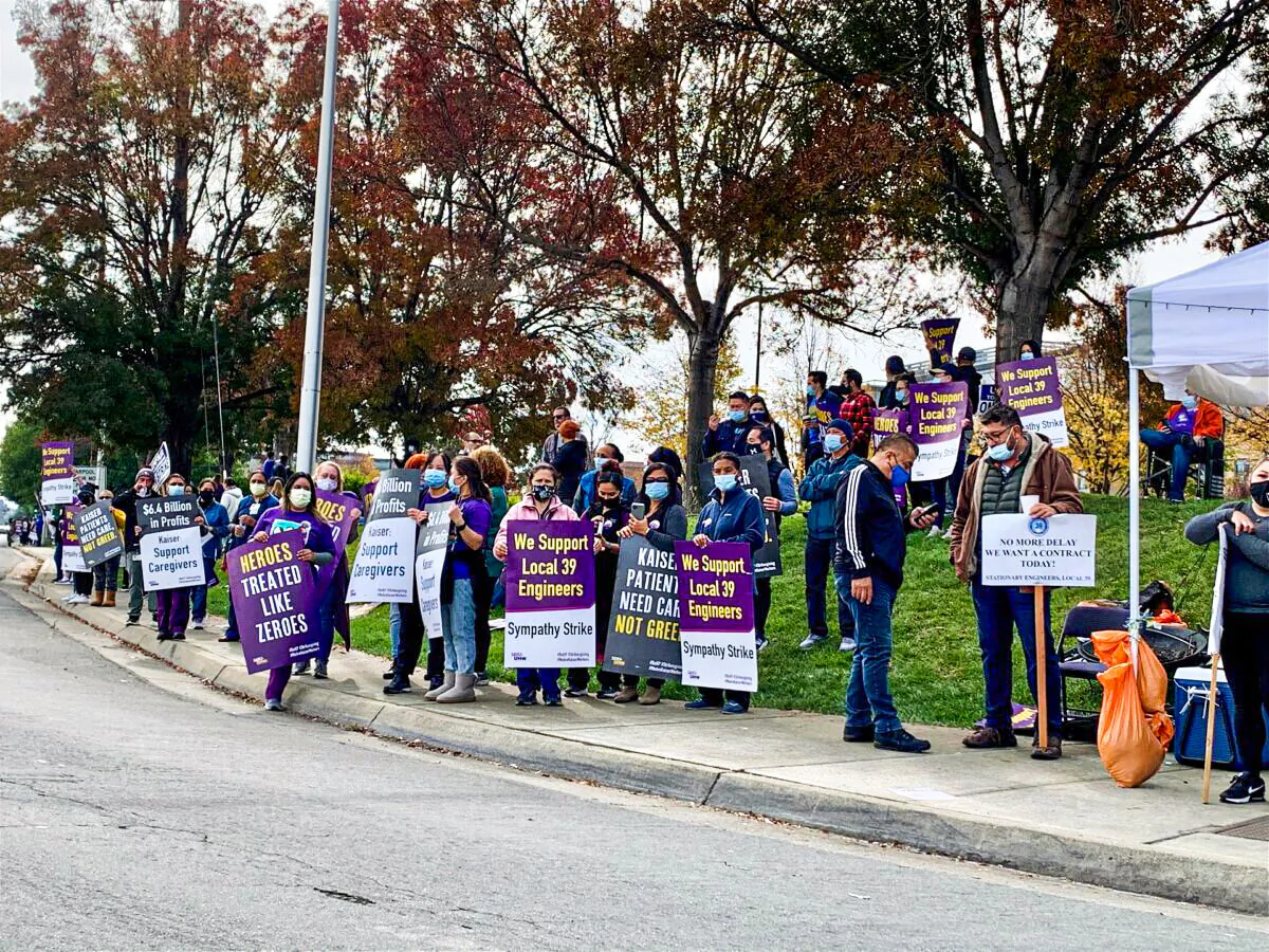 People hold signs supporting hospital engineers during a labor strike outside Kaiser Permanente in Santa Clara, Calif., on Nov. 18, 2021. (Cynthia Cai/The Epoch Times)