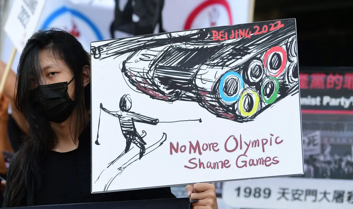 A woman holds a sign as activists rally in front of the Chinese Consulate in Los Angeles, California on Nov. 3, 2021, calling for a boycott of the 2022 Beijing Winter Olympics due to concerns over China's human rights record.  (Frederic J. Brown/AFP via Getty Images)