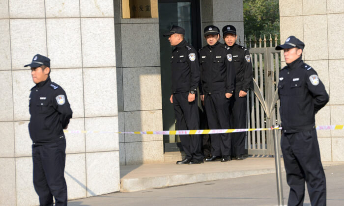 Chinese police guard the gate outside the Shandong high court building in Jinan, east China’s Shandong Province on Oct. 25, 2013. (Goh Chai Hin/AFP via Getty Images)