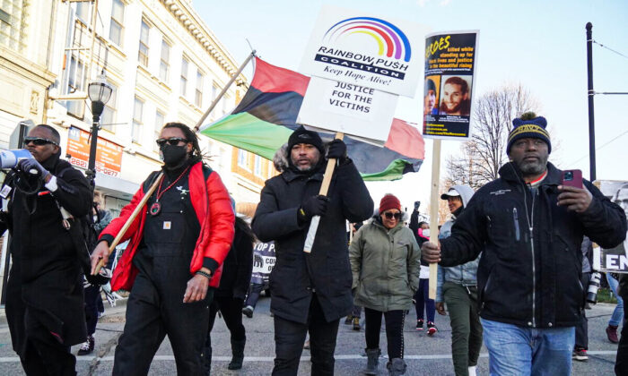 Justin Blake, Jacob Blake's uncle, waves a UNIA flag as he leads a march protesting Kyle Rittenhouse's acquittal by jury in Kenosha, Wis., on Nov. 21, 2021. (Jackson Elliott/The Epoch Times)