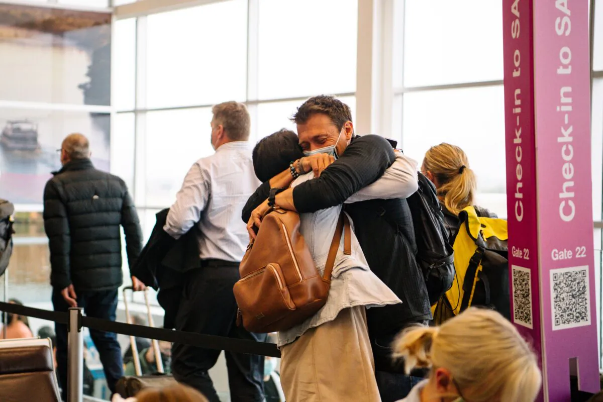 Two people are seen hugging each other after one arrives from a Melbourne flight this morning in Adelaide, Tuesday, November 23, 2021. (AAP Image/Morgan Sette)