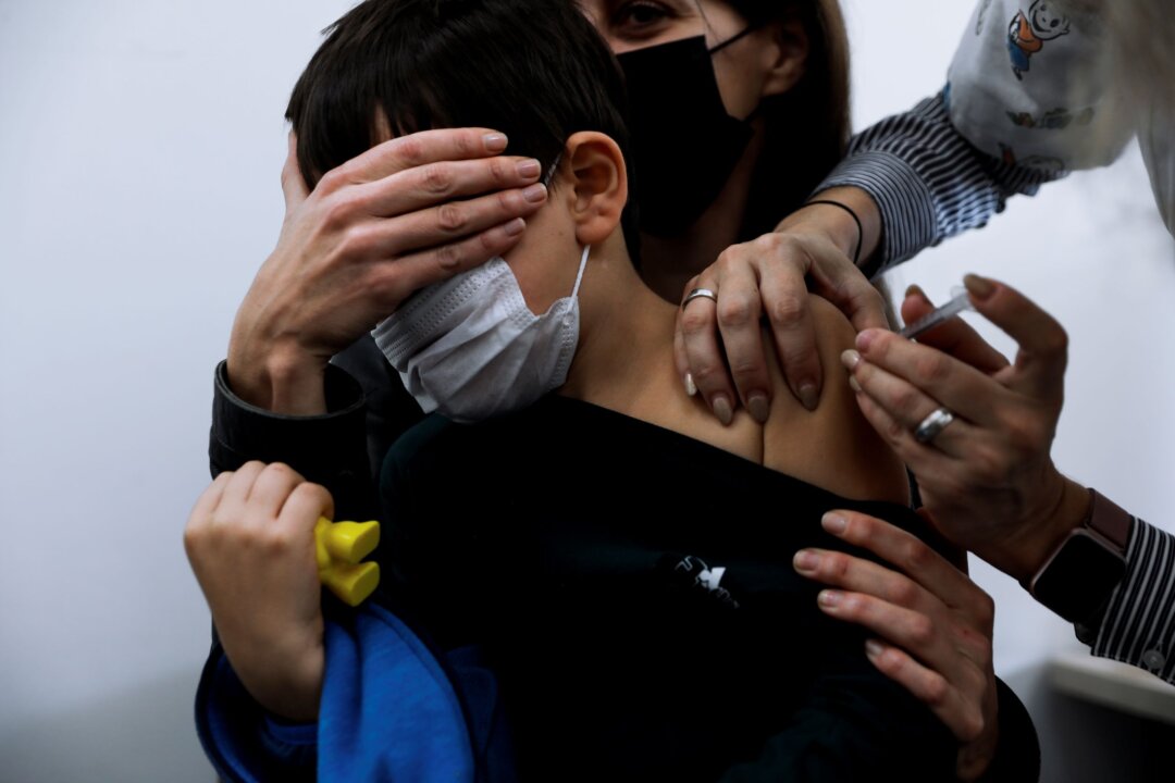 Israeli child Liam Lev Tov, 6, in the arms of his mother, receives a Pfizer-BioNTech COVID-19 vaccine from medical staff at Clalit Health services in Tel Aviv, Israel, on Nov. 23, 2021. Oded Balilty/AP