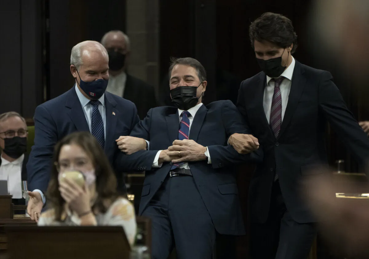 Anthony Rota jokingly fights being escorted by Prime Minister Justin Trudeau and Conservative Leader Erin O'Toole to the Speaker's chair after being elected as the Speaker of the House of Commons in Ottawa on Nov. 22, 2021. (The Canadian Press/Adrian Wyld)