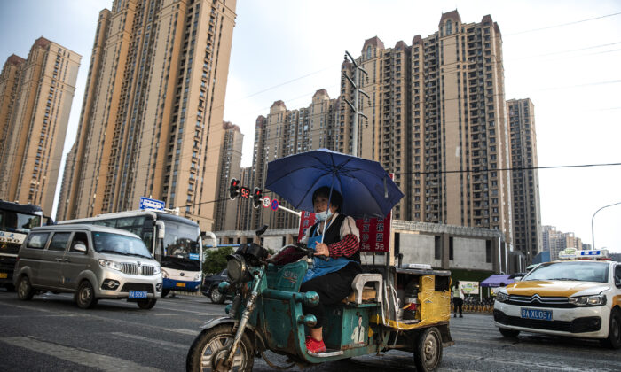 A vendor cycles through the Evergrande changqing community in the rain on Sept. 24, 2021 in Wuhan, Hubei Province, China. ( Getty Images)