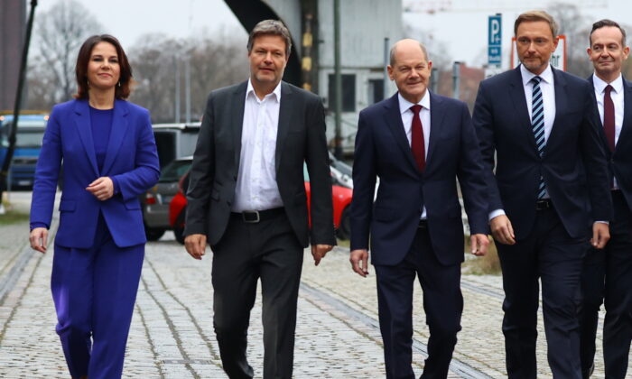 Social Democratic Party (SPD) top candidate for chancellor Olaf Scholz, Greens party co-leaders Robert Habeck and Annalena Baerbock, and Free Democratic Party (FDP) leader Christian Lindner walk after a final round of coalition talks to form a new government, in Berlin, on Nov. 24, 2021. (Fabrizio Bensch/Reuters)