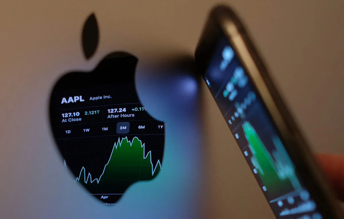 The Apple stock market ticker symbol AAPL is displayed on an iPhone screen and reflected in the logo of an iMac computer in Los Angeles, in this illustration photo taken on May 24, 2021.  (Chris Delmas/AFP via Getty Images)