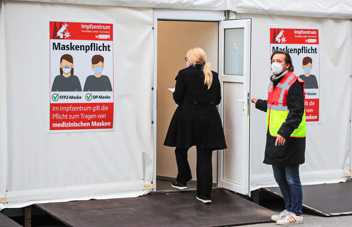 A woman enters a vaccination booth at a coronavirus disease (COVID-19) drive-in vaccination centre at Lanxess Arena in Cologne, Germany, November 23, 2021. REUTERS/Wolfgang Rattay