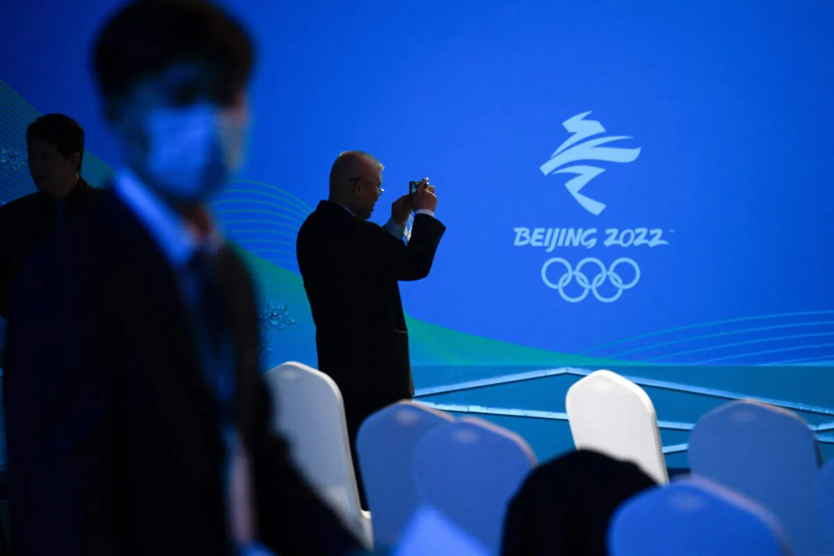 A man takes pictures of a logo of the Beijing 2022 Winter Olympic Games during the Beijing 2022 Paralympic Winter Games 100 Day countdown event at the National Aquatic Centre in Beijing, on Nov. 24, 2021. (Wang Zhao/AFP via Getty Images)